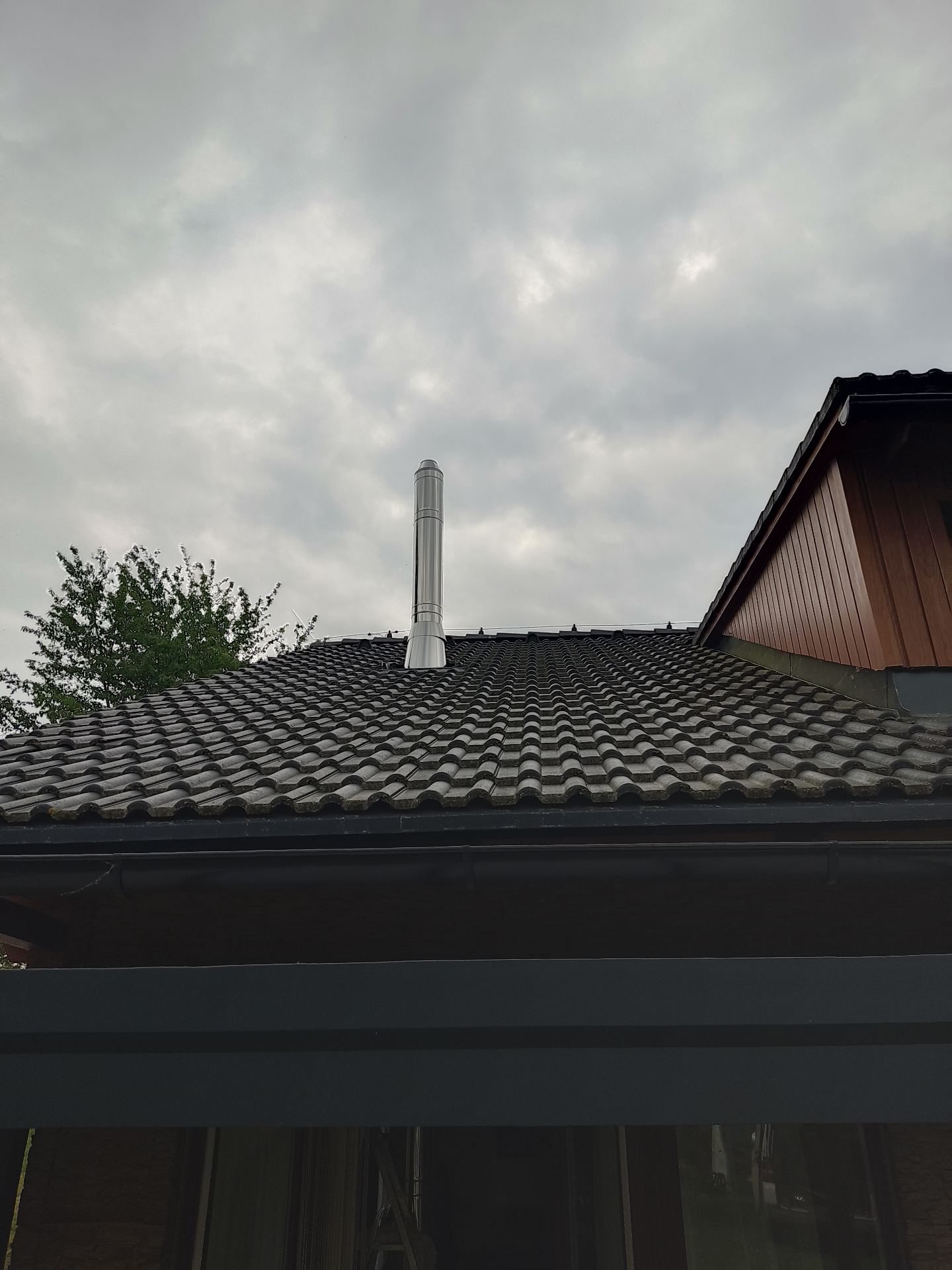 Nerezový komín nad taškovou střechou